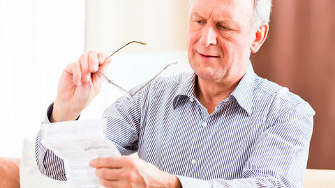 Mann liest sich den Beipackzettel von Ibuprofen durch