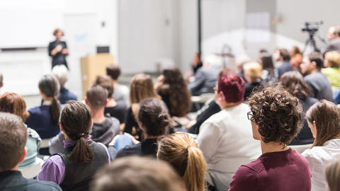 Frau mit Mikro spricht vor Publikum