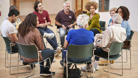 Menschen sitzen in einer Gruppe zusammen