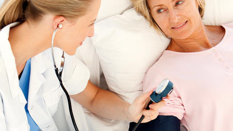 Ärztin misst bei einer Frau den Blutdruck