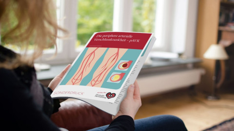 Frau hällt den neuen Sonderdruck pAVK in der Hand