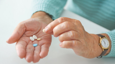 Eine Frau hat Medikamente in der Hand zum einnehmen
