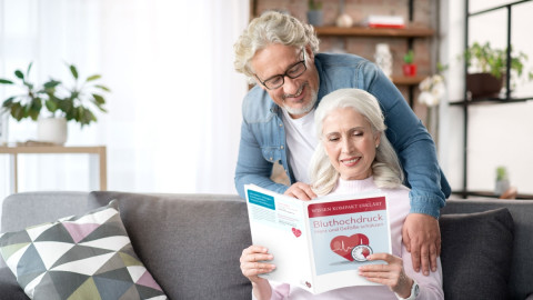 Ehepaar schaut sich die Bluthochdruck-Broschüre an
