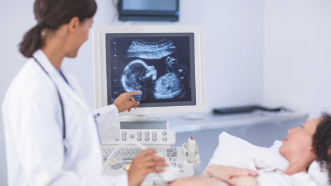 Kardiologin führt bei einer schwangeren ein Herz-Screening durch